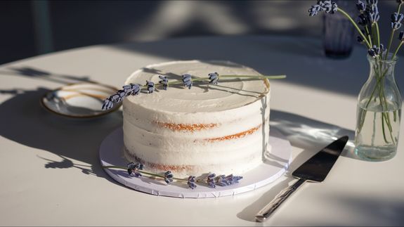 Female confectioner decorating homemade cake with berries