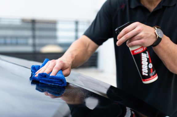 A Person in Black Shirt Cleaning Black Car
