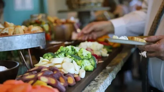 Catering Appetizers on Wooden Board Next to Empty Champagne Glasses