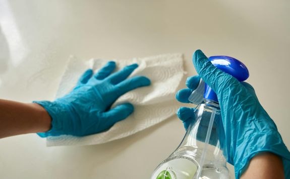 Person Wearing Gloves Holding A Bottle
