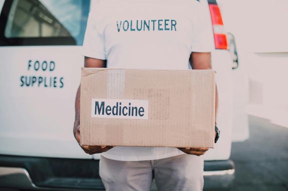 A Man Carrying a Brown Box