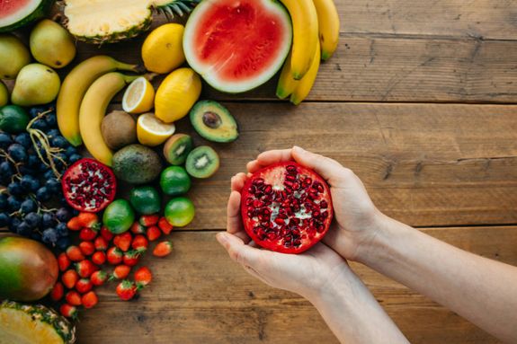 Overhead Shot of a Person Holding a Pomegranate