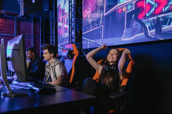 A Woman with Headset on Her Neck Sitting on the Chair