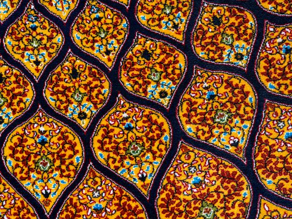 Close-up of a vibrant traditional woven carpet with intricate floral design.