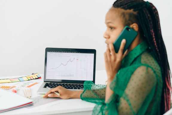 Woman in Talking on the Phone Near a Laptop