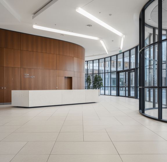 Interior of spacious modern studio apartment with minimalist white furniture in kitchen and comfortable soft sofa in living room