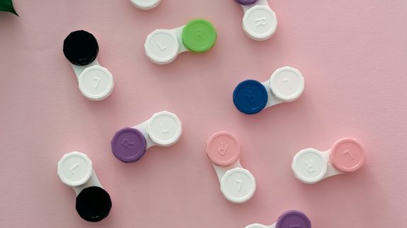 Crop unrecognizable female ophthalmologist showing eyeglasses