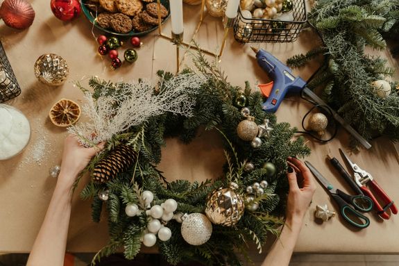 A Hand Holding a Hanging Christmas Wreath