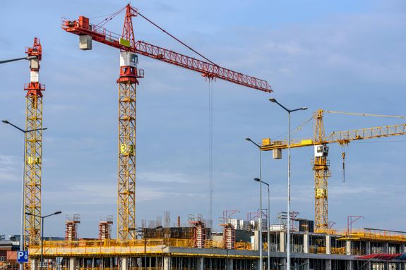 Three Yellow and Red Tower Cranes Under Clear Blue Sky