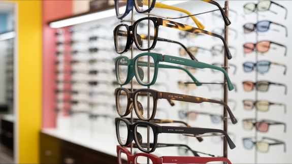 Crop unrecognizable female ophthalmologist showing eyeglasses