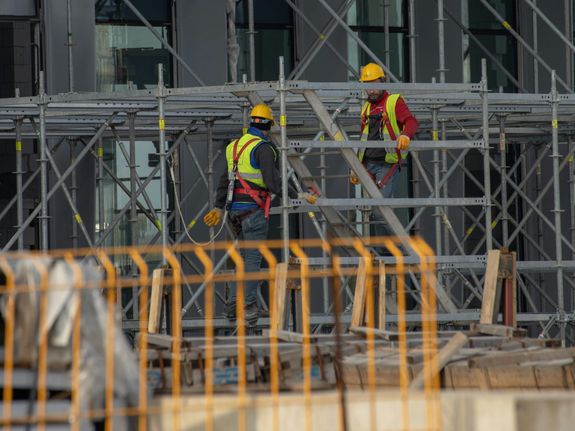 Men in Helmets Working on Scaffolding on Building Site