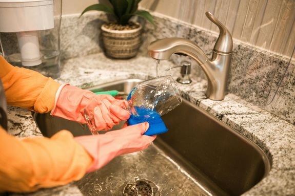 Person Cleaning Wine Glass on Sink 