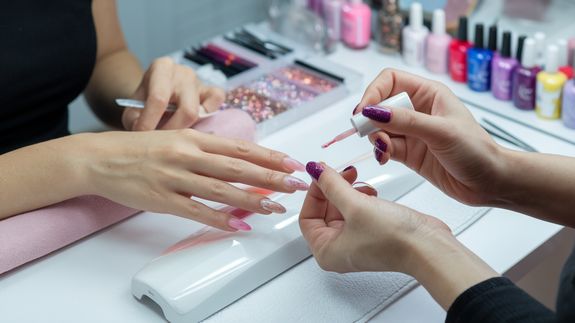 Close-up Photo of Woman With Yellow, Glitter on Her Face, and Yellow Nails
