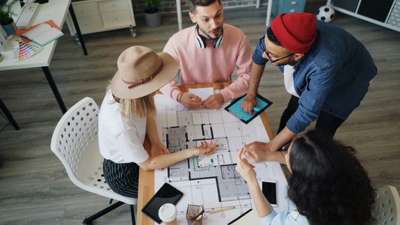 A group of people at a table with a laptop