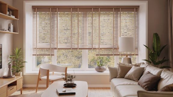 White table with lamp and chair under shelf with mirror near window decorated with pink curtains