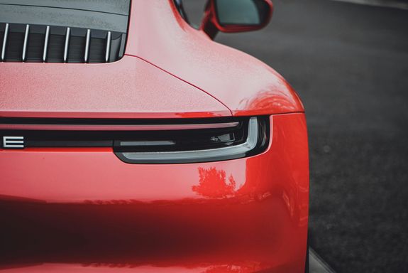 Detailed close-up of a red sports car showcasing luxury and design with a focus on the rear tail light.