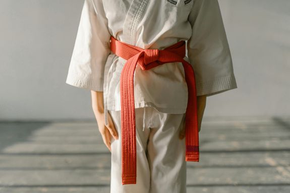 Person Wearing a Karate Uniform with Orange Belt