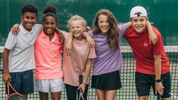Tennis player standing with racket and ball