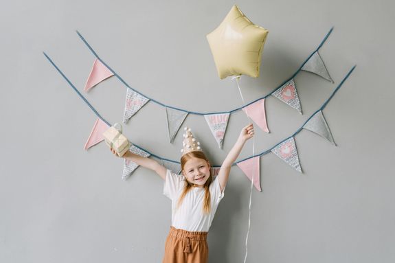Photograph of a Girl Holding a Box and a Balloon
