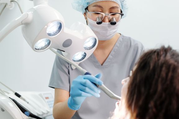 Woman in Gray Scrub Suit Holding Dental Equipment