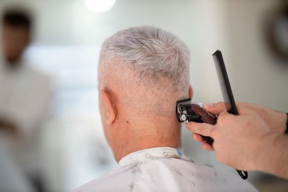 A Barber Trimming a Man's Beard