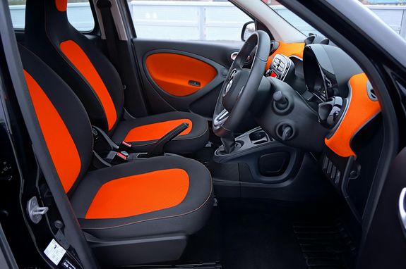 Explore this modern car interior featuring striking orange and black seats with a sleek dashboard.