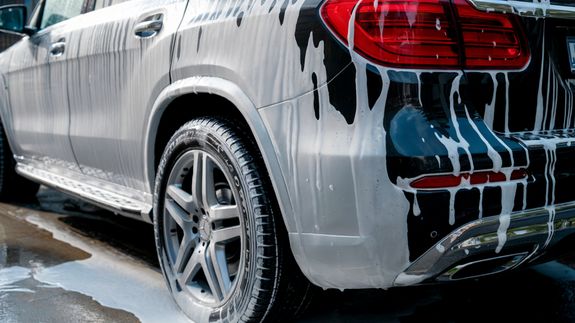 Photo of a Woman Washing a Black Car