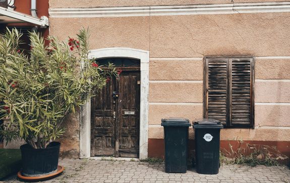 Garbage Bins beside a Wooden Window