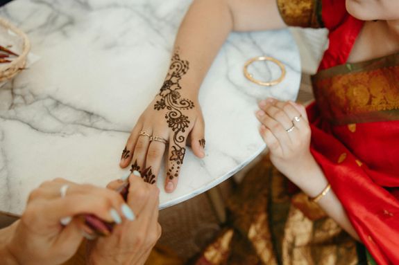 A Person Putting Henna Tattoo on Another Person's Hand