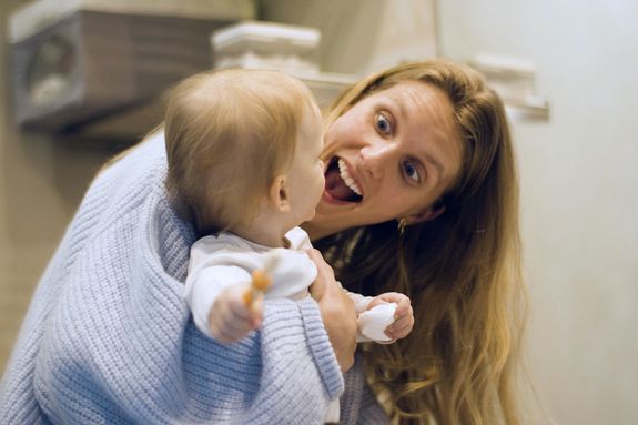 Woman in Blue Sweater Playing with her Baby