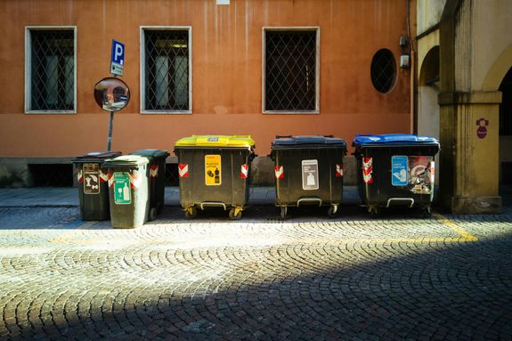 Black and Blue Trash Bins Outside a Building