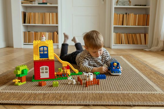 Boy Lying Down on Floor and Playing with Toys