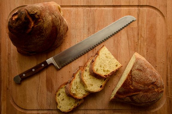 Sliced Bread and a Knife on Wooden Chopping Board