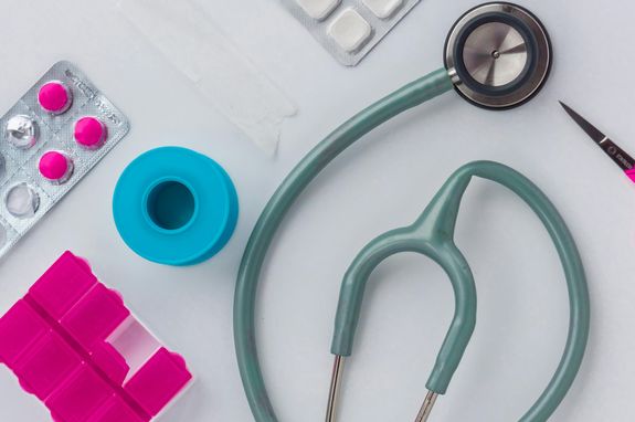Top View of a Stethoscope beside Tablets and a Pill Container