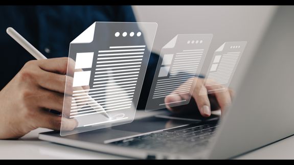 Focused woman analyzing financial reports in a modern office setting with charts and graphs.