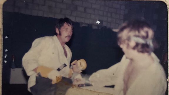 silhouette of person standing on rock surrounded by body of water