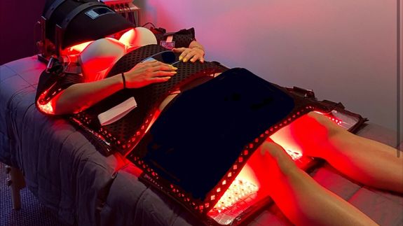 silhouette of person standing on rock surrounded by body of water