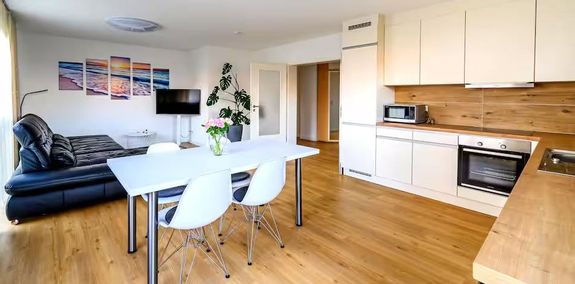 Crop unrecognizable coworkers in formal wear standing at table with laptop and documents while greeting each other before meeting