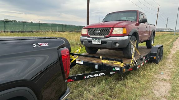 A white suv parked next to a boat