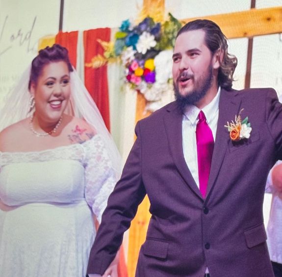A bride and groom walk out of the church