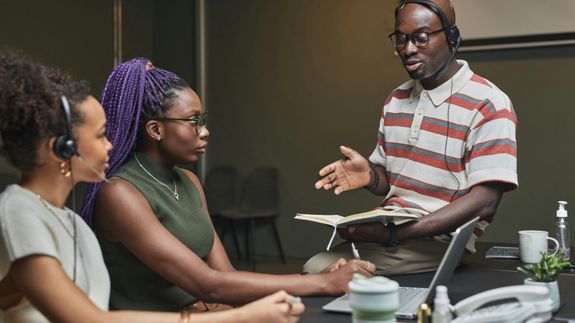 A couple discusses financial documents with their advisor, highlighting investment strategies.