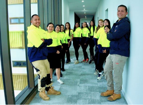 Close-up of a person cleaning hands with cloth by a kitchen sink indoors.