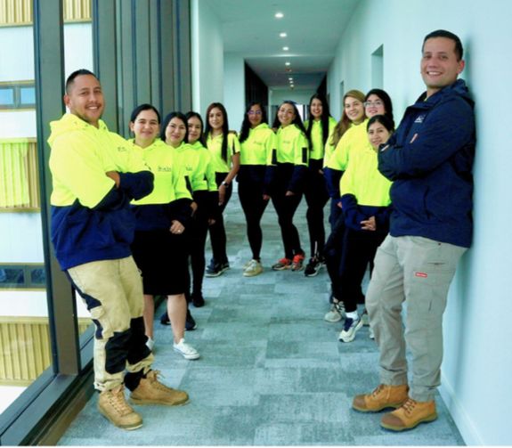 Anonymous person wearing yellow latex gloves washing golden faucet with sponge in modern bathroom while cleaning house