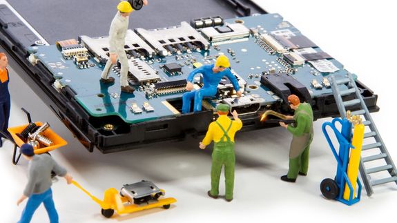 Detailed shot of smartphone repair with a screwdriver and hand close-up.