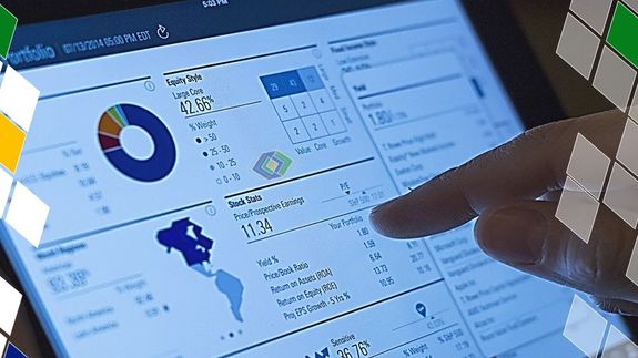 a Laptop with Graphs on Screen Beside a Smartphone on Paper Money