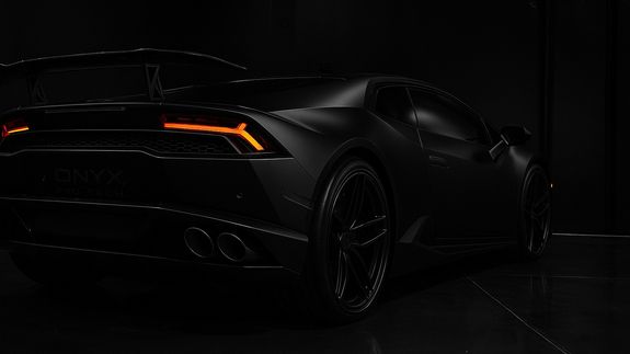 Luxury contemporary automobile with bright indicators parked on asphalt near fresh green grass