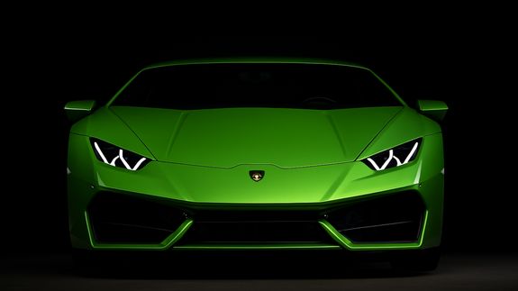 Detailed view of a shiny red car's tail light with bokeh reflections.