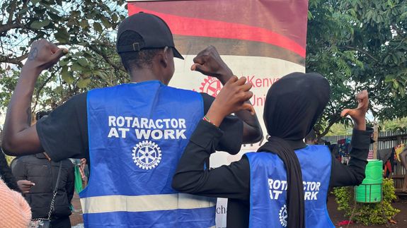 Scenery of contemporary city district with modern apartment buildings and vast parking area amidst green lush trees situated on hilly valley on sunny weather