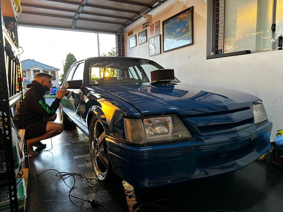 Close-up of a worker buffing red car paint for shine and maintenance.