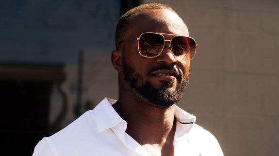 Classic vintage camera with lens and leather case on white surface.